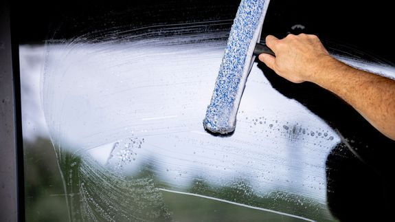 Window cleaner using a squeegee to create a clear glass finish